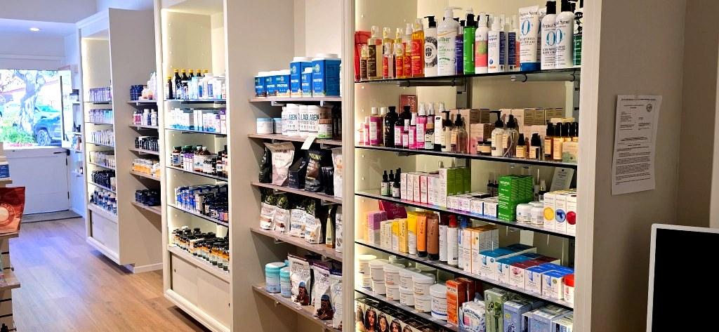 Shelves of vitamins, collagen, and natural wellness products in the apothecary