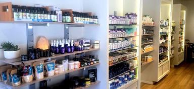 Essential oils, bath salts, and botanical care on warm wood shelves